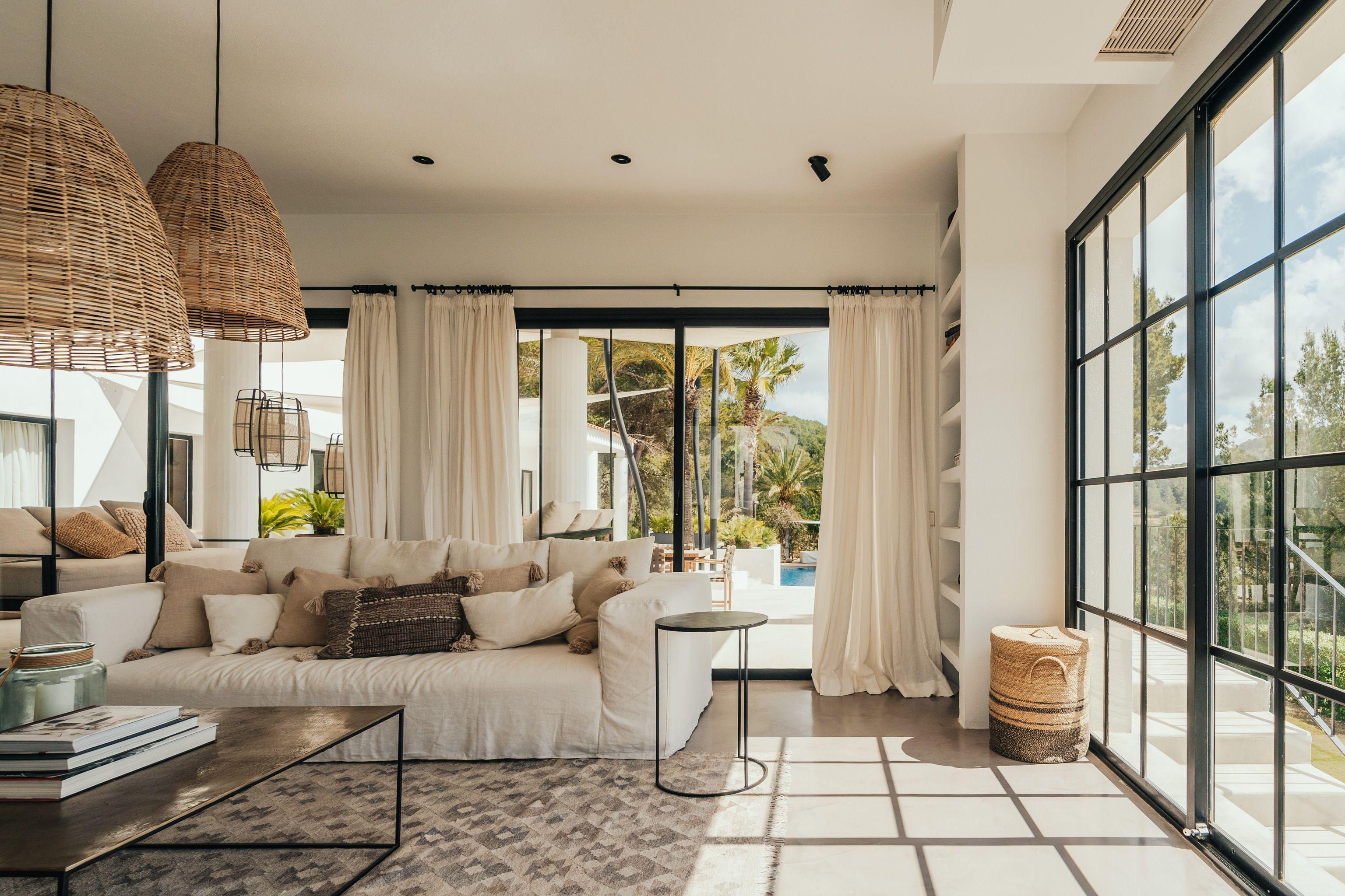 Bright modern living room with woven rattan pendant lights, neutral décor and natural daylight, showcasing stylish living room lighting ideas.