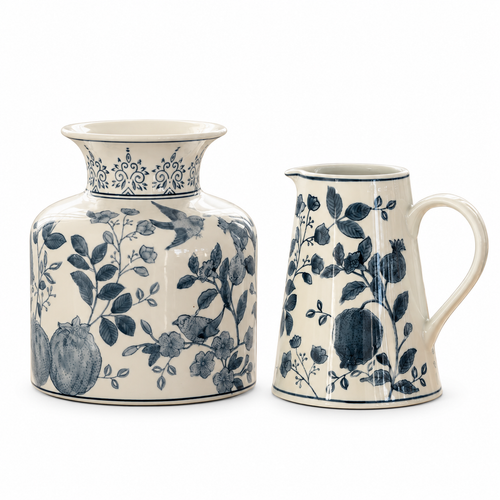 Two ceramic pitchers in a matching blue and cream floral pomegranate pattern, shown on a clean white background.