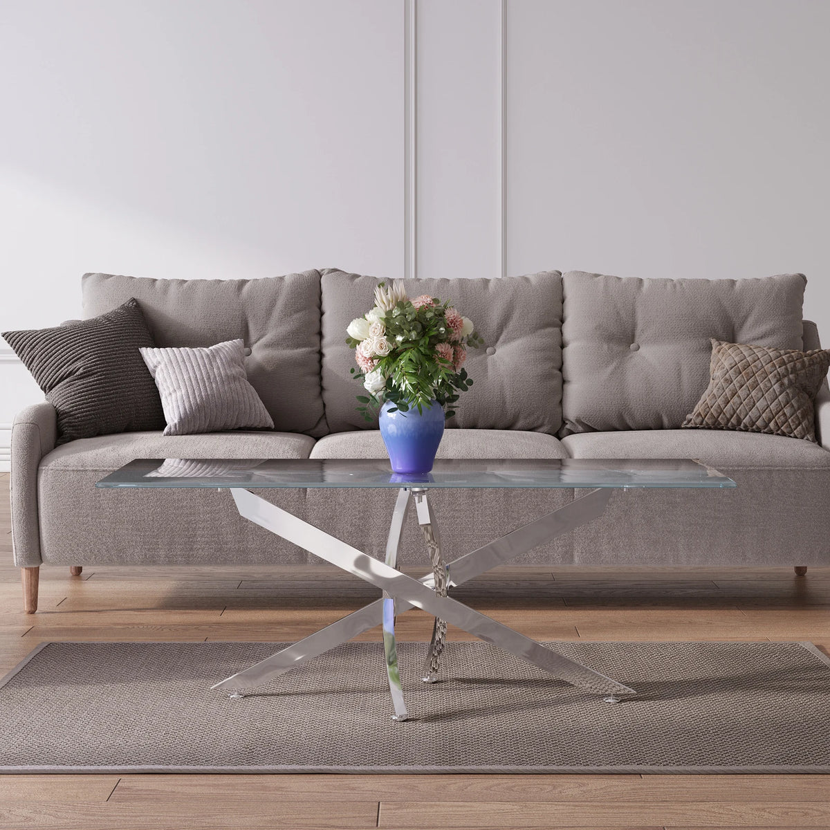 Gray sectional sofa with a glass coffee table and decorative items in a living room setting.