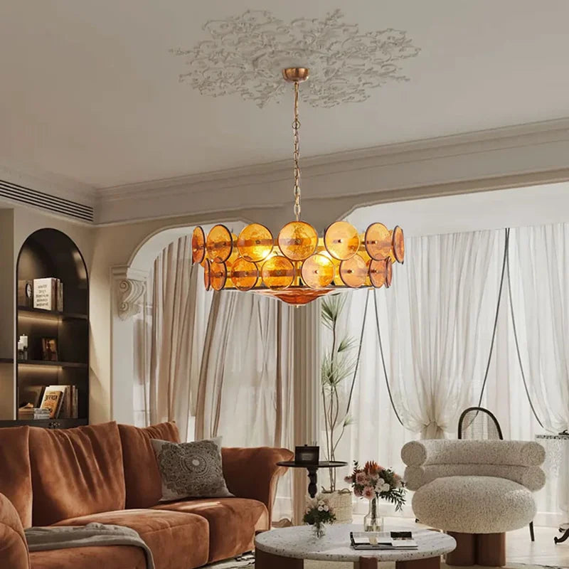 Modern living room with a stylish chandelier, brown sofa, and decorative elements.