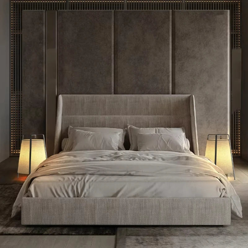 Modern bedroom with a large upholstered bed and decorative headboard.