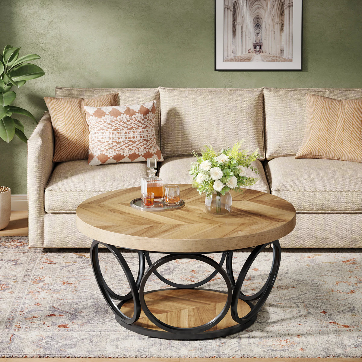 Round wooden coffee table with metal base in front of a beige sofa with decorative pillows.