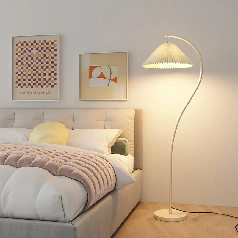 Modern bedroom with a bed, floor lamp, and wall art.