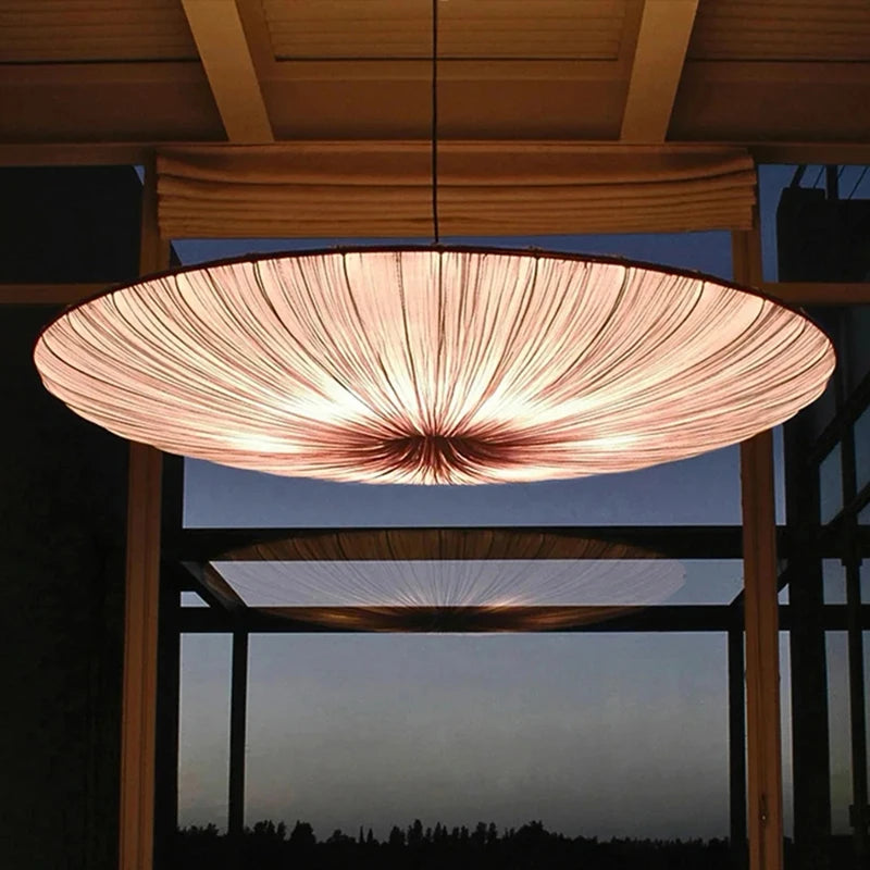 Large pendant light fixture hanging above a table with a dark background