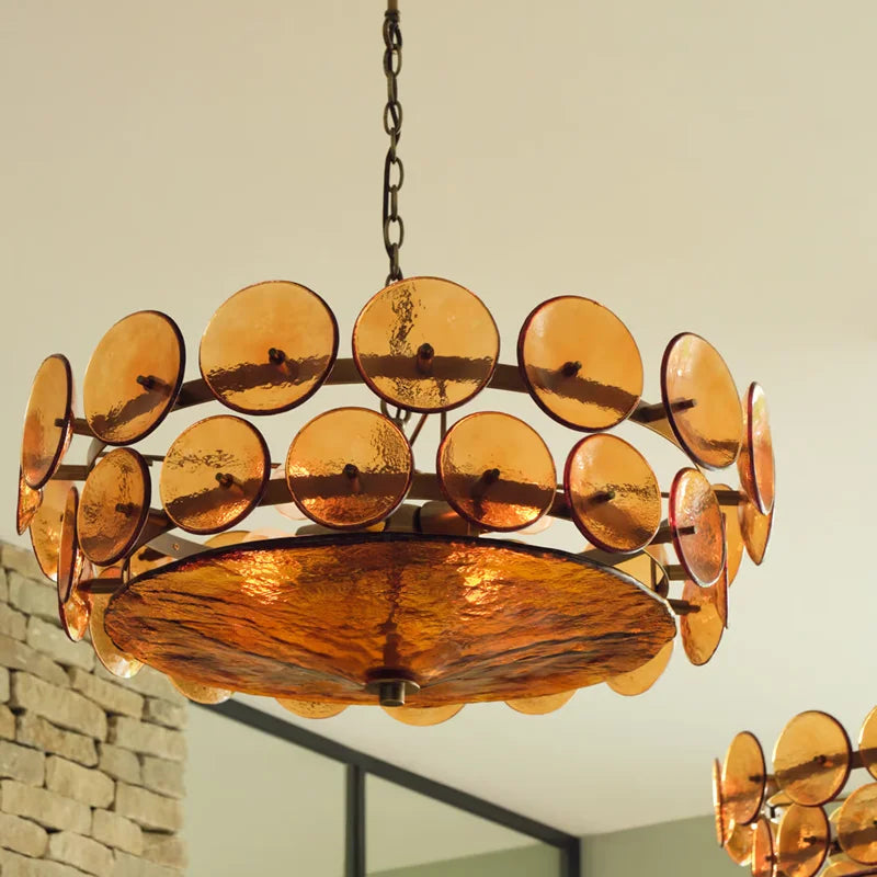 Chandelier with circular amber glass panels on a neutral background