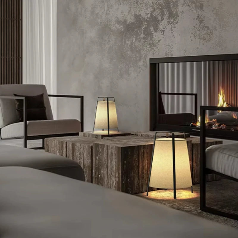Modern living room with gray sofa, wooden coffee table, and lit lamps.