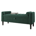 A dark green upholstered storage bench with tufted detailing, rolled arms, dark legs, and a small pull handle on the front, shown on a plain white background with two books resting on top.