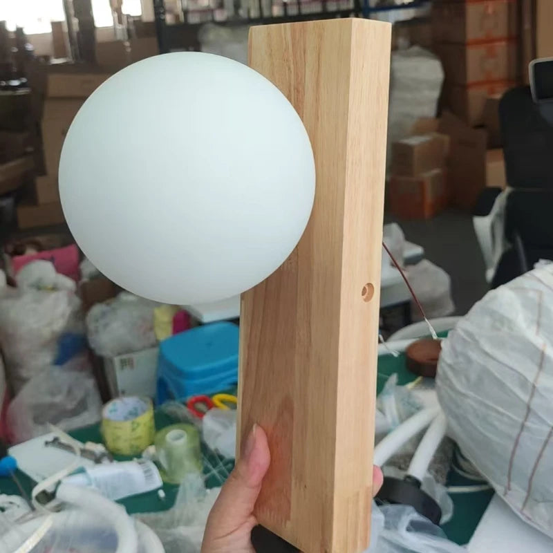 Wall lamp held by a hand in a cluttered indoor setting