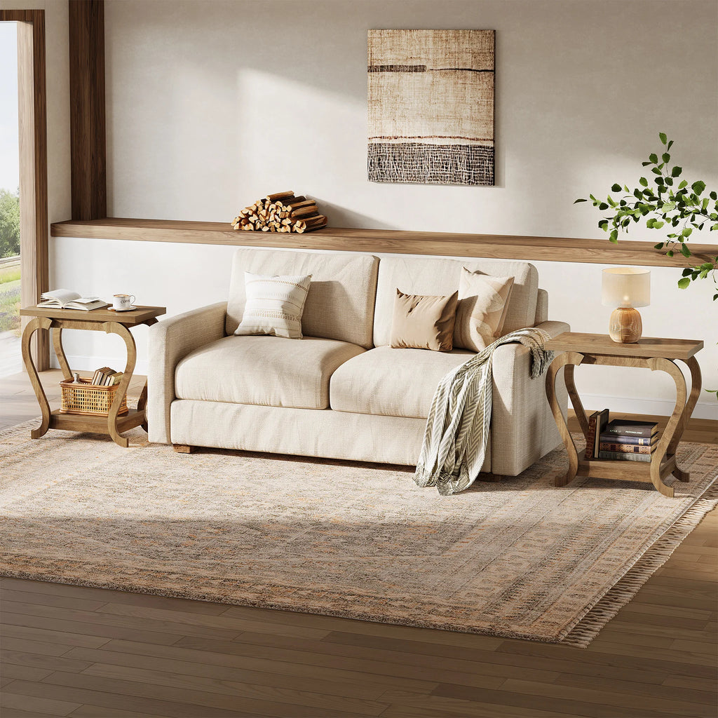 Beige sofa in a living room with wooden side tables and a rug.