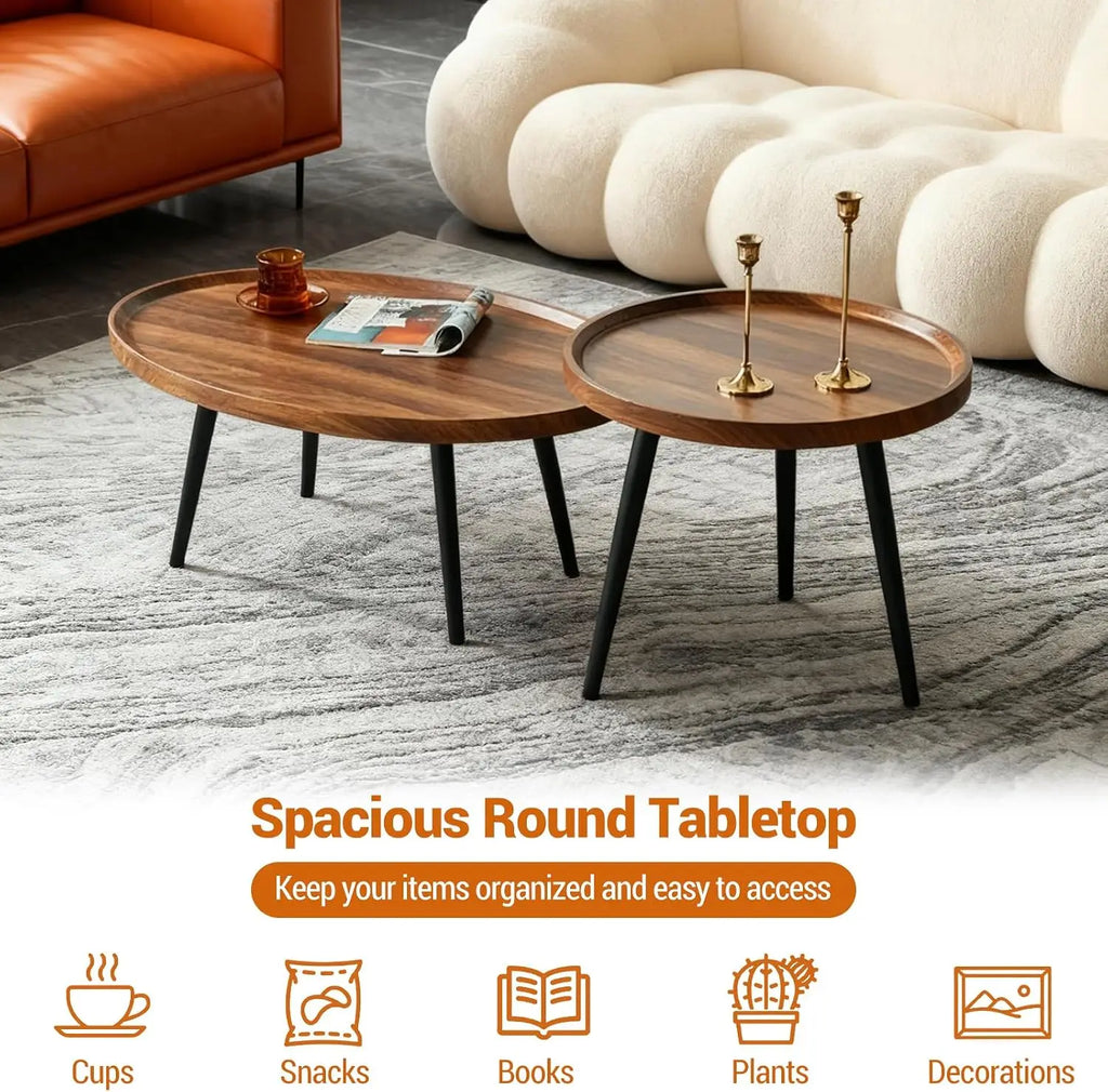 Two round nesting coffee tables with dark brown wood tops and black tapered legs, shown in a modern living room setting on a gray rug. The tables have decorative items on them, and there is promotional text at the bottom reading 'Spacious Round Tabletop' with icons for cups, snacks, books, plants, and decorations.