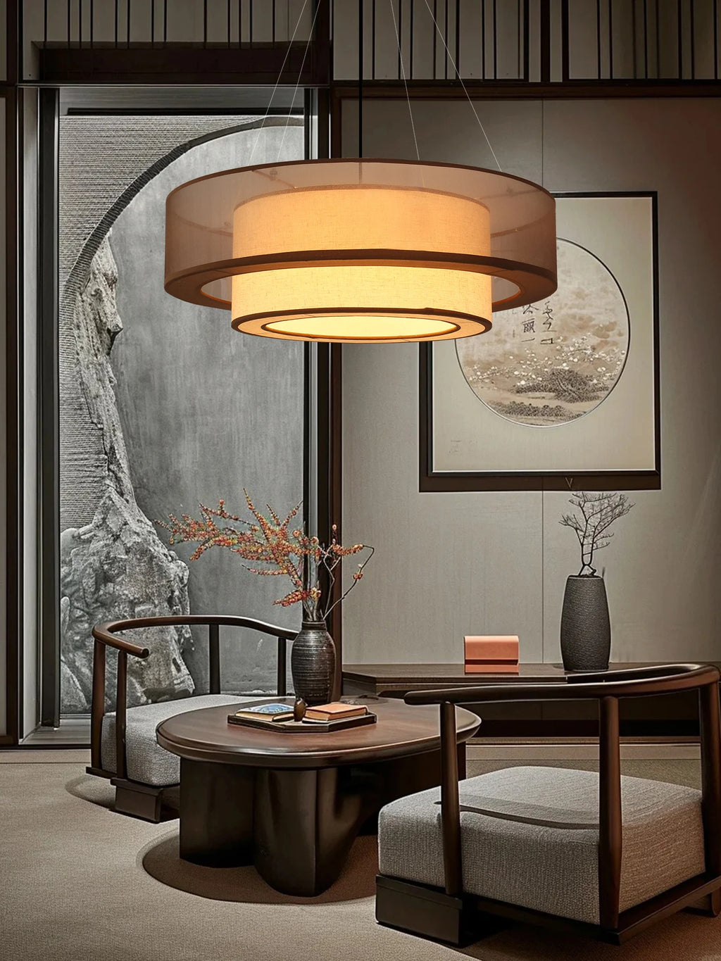 Modern living room with a round wooden table, chairs, drum like ceiling light and decorative elements.