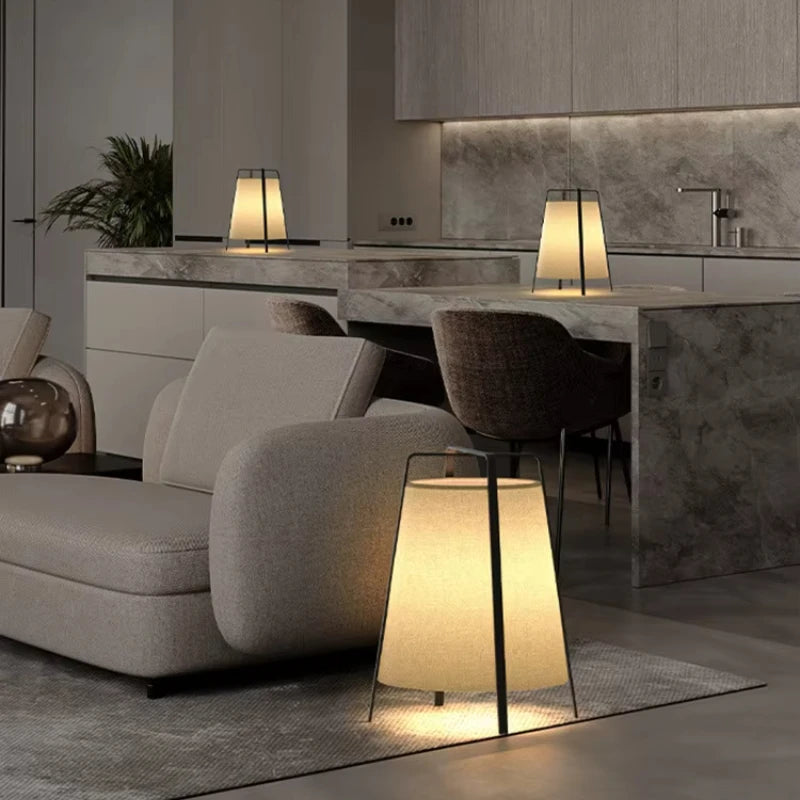 Modern living room with gray sofa, table, and floor lamp.