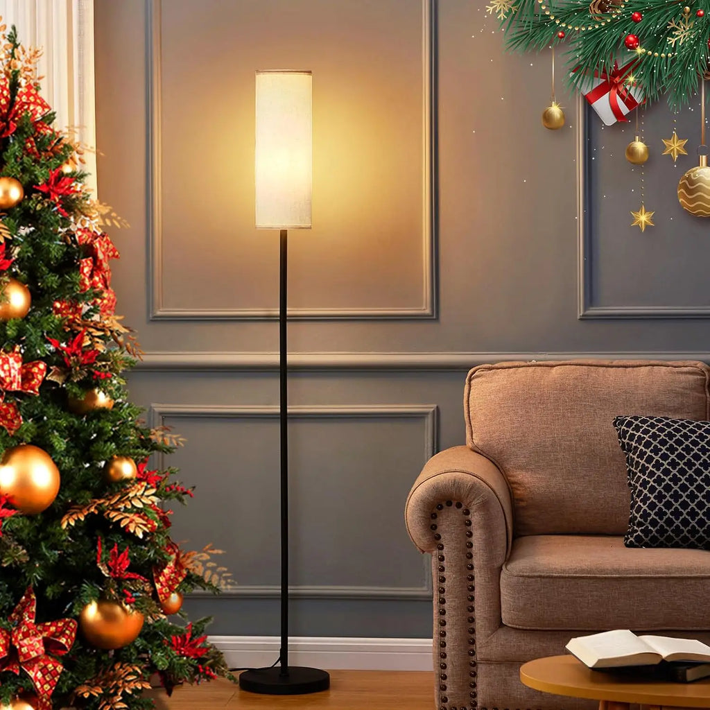 Living room with a Christmas tree, floor lamp, and decorated wall