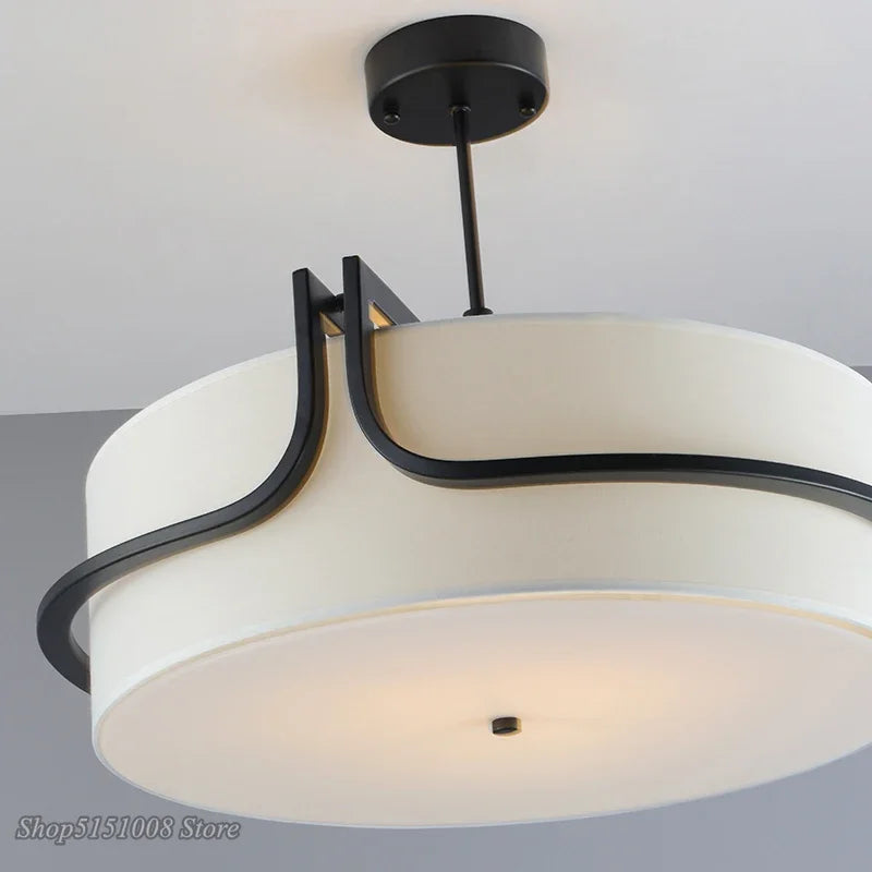 Ceiling light fixture with white shade and black metal frame on a neutral background
