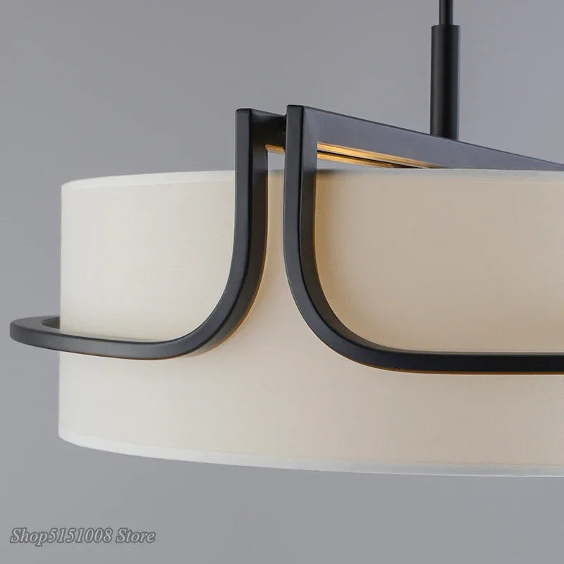 Close-up of a modern chandelier with black metal frame and beige lampshades on a gray background
