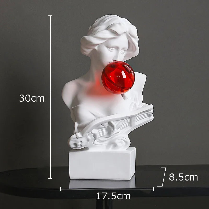 White bust sculpture light of a woman blowing a red bubblegum bubble, shown on a black surface with dimension lines indicating 30 cm height, 17.5 cm width, and 8.
