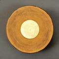 Round woven object with a central light source on a gray background
