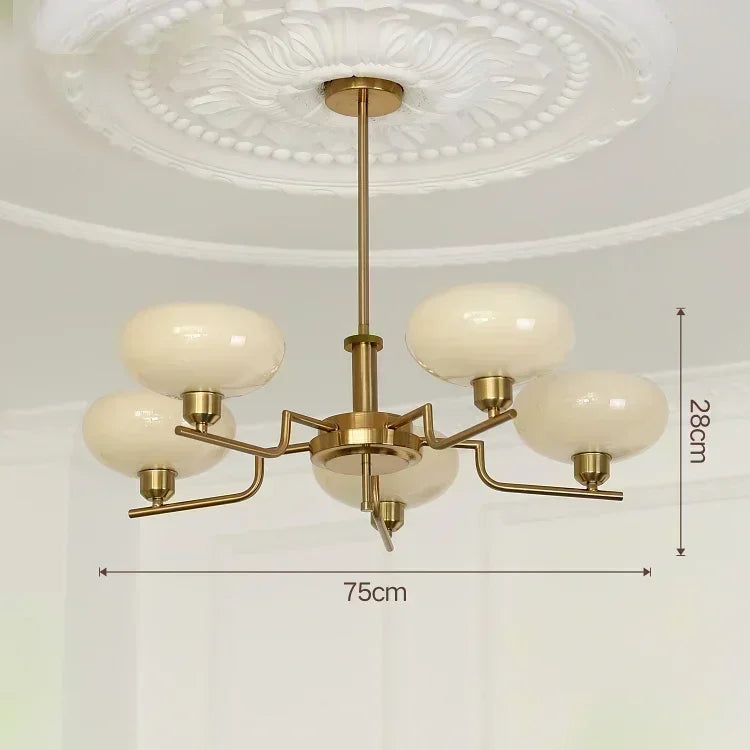 Gold chandelier with white glass shades on a white ceiling