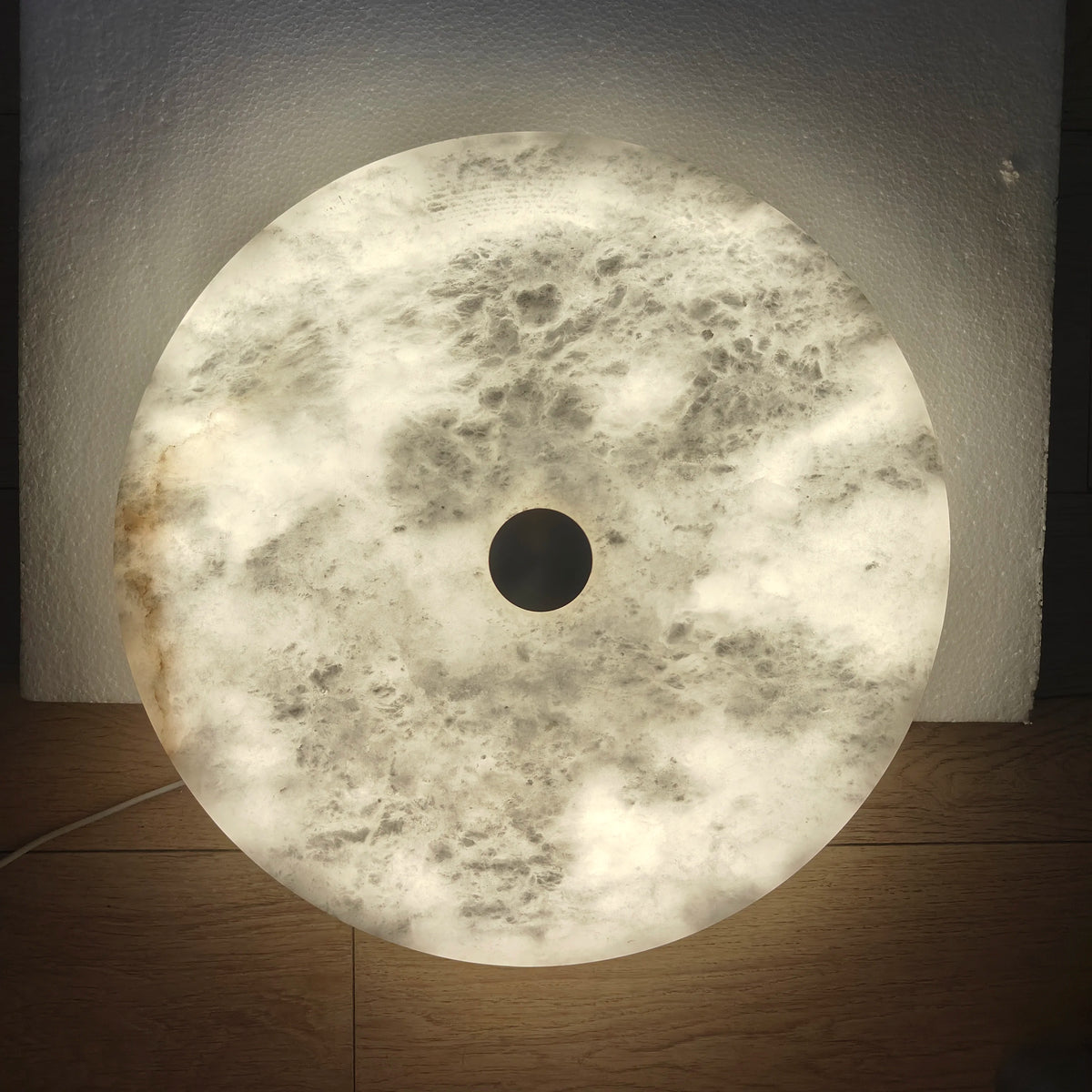 Illuminated Round ceiling light fixture on a wooden surface