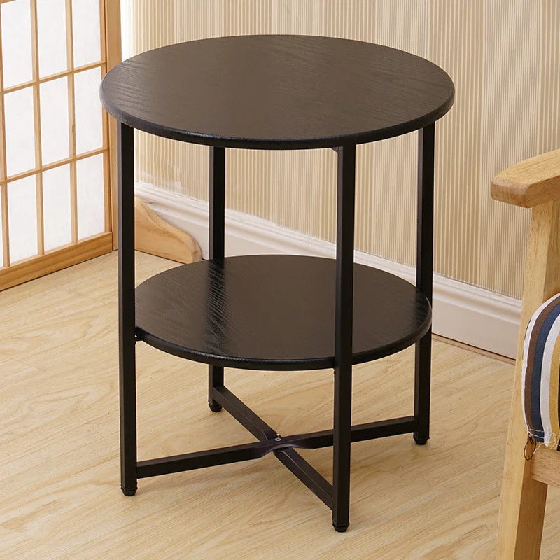 Black round side table with a wooden chair in the background