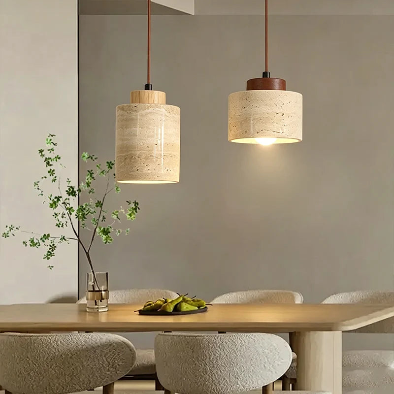 Dining room with pendant lights, table, and chairs.