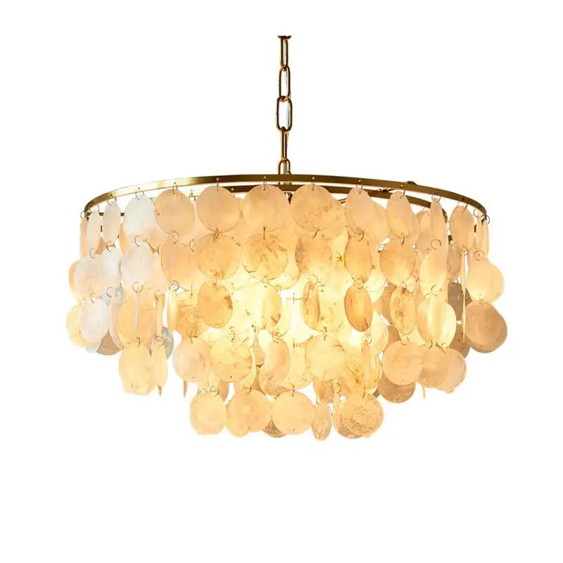 A modern circular chandelier featuring a gold-toned metal frame and hanging disc elements made of natural seashells, shown against a solid white background.