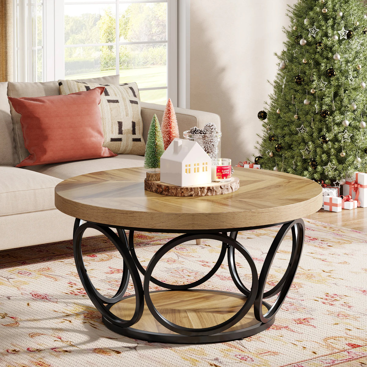 Wooden coffee table with decorative items in a living room with a Christmas tree.