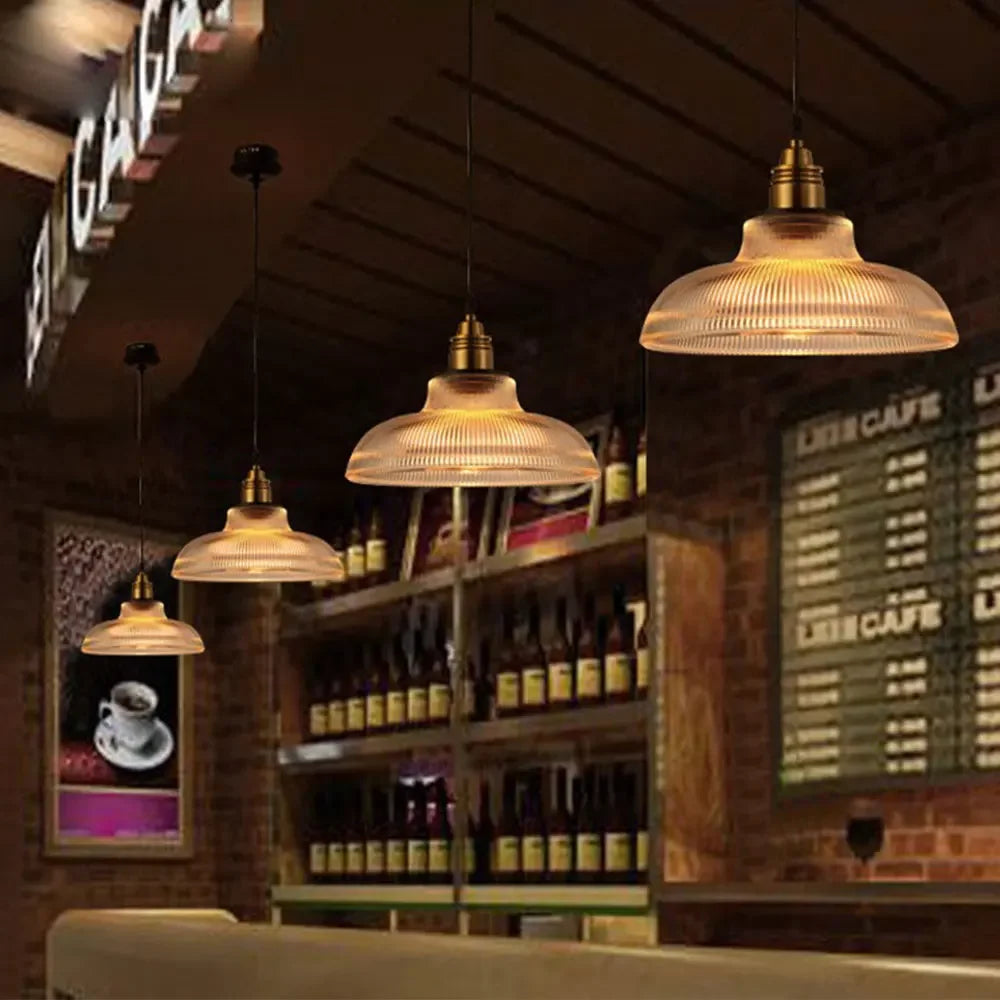 Pendant lights hanging in a bar setting with shelves and a menu board in the background.