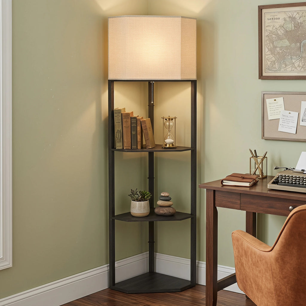 A tall black metal corner floor shelf with a beige fabric drum lampshade, styled in a home office corner next to a wooden desk and chair.
