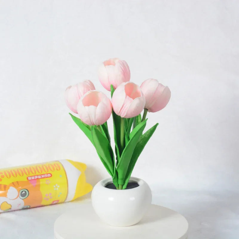 Pink tulips table lamp in a white vase on a light surface with a white background