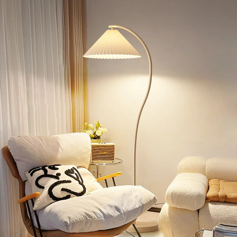 Modern living room with a floor lamp, armchair, and decorative pillows.