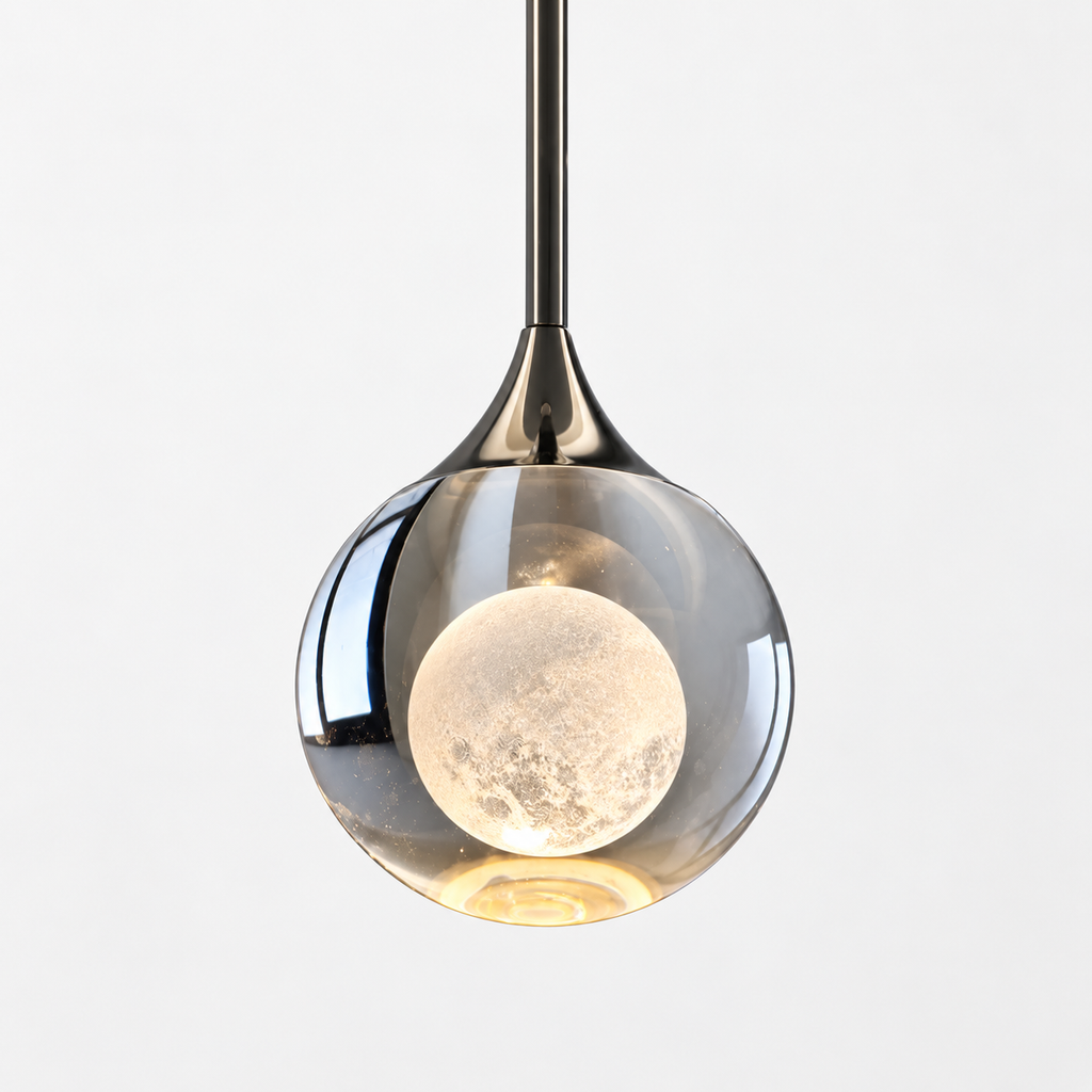 A modern pendant light with a clear glass globe shade, a polished dark metal stem, and a glowing moon-shaped bulb inside, shown against a plain light gray background.