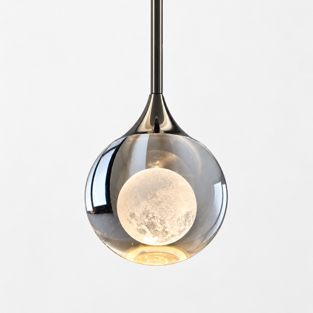 A modern pendant light with a clear glass globe shade, a polished dark metal stem, and a glowing moon-shaped bulb inside, shown against a plain light gray background.